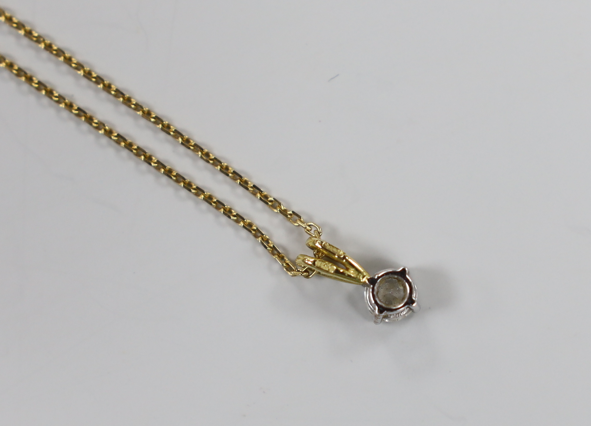 A modern 18ct gold and solitaire diamond set pendant, 10mm, on an 18ct gold chain, 40cm, gross weight 2.8 grams.